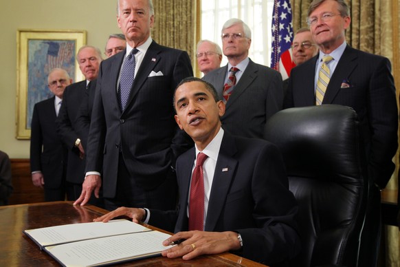 FILE - In this Jan. 22, 2009 file photo, President Barack Obama, accompanied by Vice President Joe Biden and retired military members speaks in the Oval Office of the White House in Washington, Thursd ...