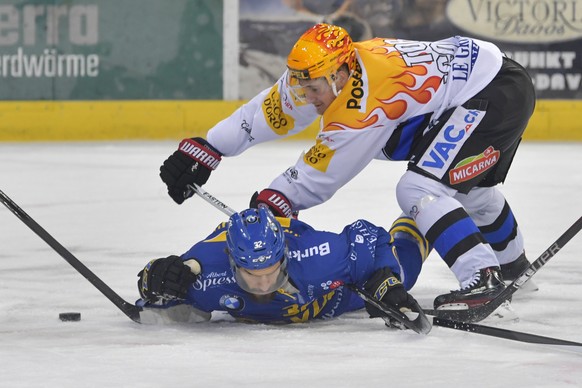 Der Fribourger PostFinance TopScorer Roman Cervenka, rechts, haelt den Davoser Noah Schneeberger am Boden, beim Eishockey Meisterschaftsspiel in der Qualifikation der National League zwischen dem HC D ...