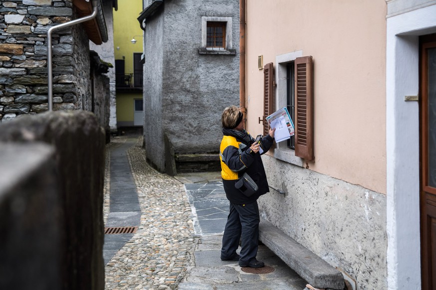 ARCHIV - ZUM SERVICEAUSBAU DER SCHWEIZERISCHEN POST STELLEN WIR IHNEN DIESES ARCHIVBILD ZUR VERFUEGUNG - Die Poestlerin Tiziana Quanchi gibt einer Kundin Post durch ein Fenster auf ihrer Tour am Donne ...