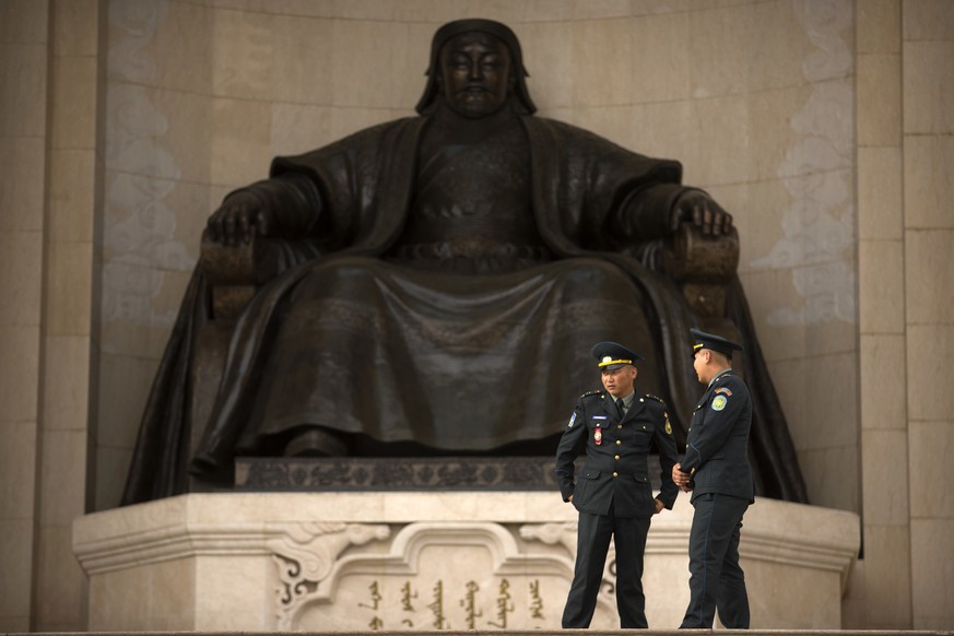 Officers stand guard in front of the statue of Genghis Khan at Sukhbaatar Square in Ulaanbaatar, Sunday, July 10, 2016. Mongolians will celebrate the anniversary of Genghis Khan's march to world conqu ...