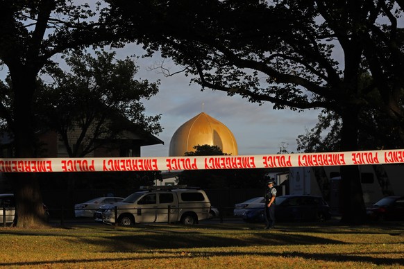 FILE - In this March 17, 2019 file photo, a police officer stands guard in front of the Masjid Al Noor mosque in Christchurch, New Zealand, where one of two mass shootings occurred. According to a rep ...