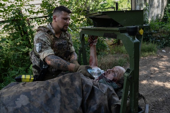 In this photo provided by Ukraine's 93rd Kholodnyi Yar Separate Mechanized Brigade press service and taken Friday, July 3, 2026, a soldier evacuates a wounded resident on a ground vehicle in the  ...