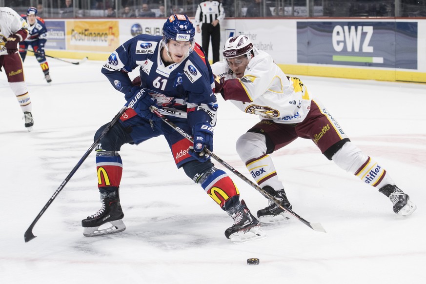 Der Zuercher Fabrice Herzog, links, spielt um den Puck mit Servettes Henrik Toemmernes, rechts, waehrend dem Eishockey-Meisterschaftsspiel der National League zwischen den ZSC Lions und dem Geneve Ser ...