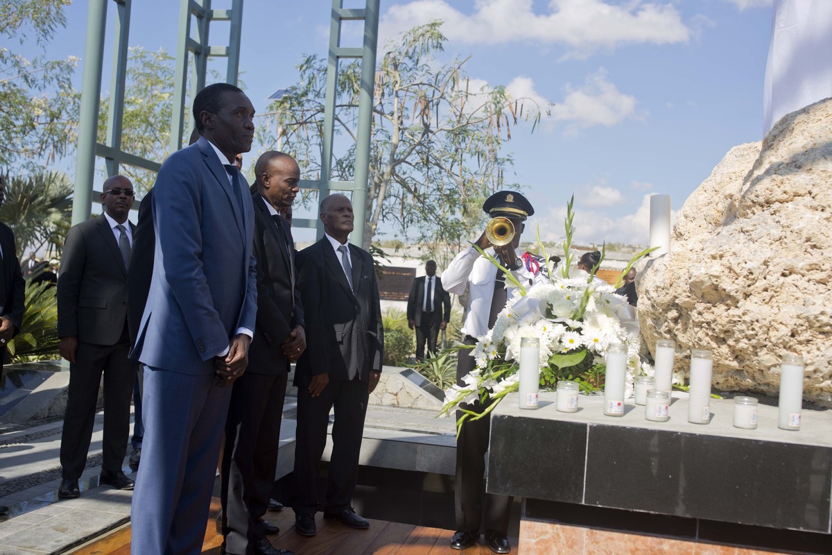 Haiti's President Jovenel Moise, center, stands with senate president Joseph Lambert, left, and Jules Cantave, right, president of Supreme Court of Cassation attending a memorial service at Titan ...