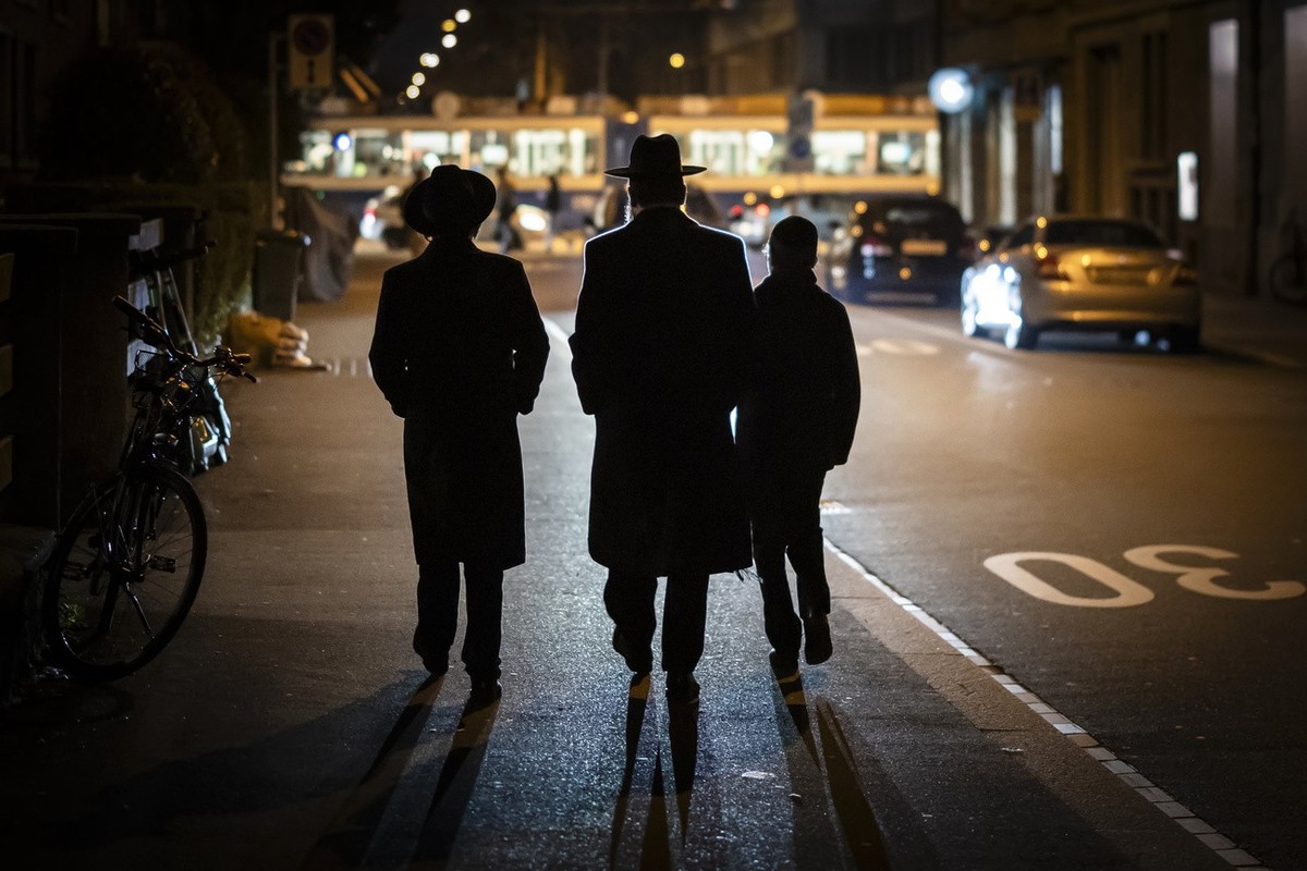 Ein Mann und zwei Jungen in juedisch-orthodoxer Kleidung gehen in Zuerich Wiedikon einer Strasse entlang, am Freitag, 8. Maerz 2024 in Zuerich. (KEYSTONE/Michael Buholzer)