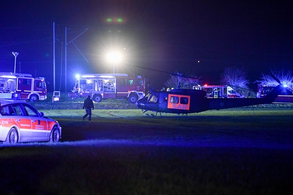 epa06369876 A helicopter and fire-fighting vehicles stand ready at the site of the crash after a passenger train collided with a freight train in Meerbusch, Germany, 05 December 2017. According to loc ...