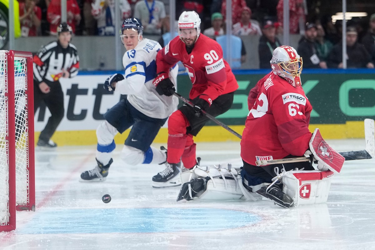 Finland's Jesse Puljujarvi (13), Switzerland's goalkeeper Leonardo Genoni (63), Switzerland's Roman Josi (90) in action during overtime in the 2026 IIHF Men's Ice Hockey World Cham ...