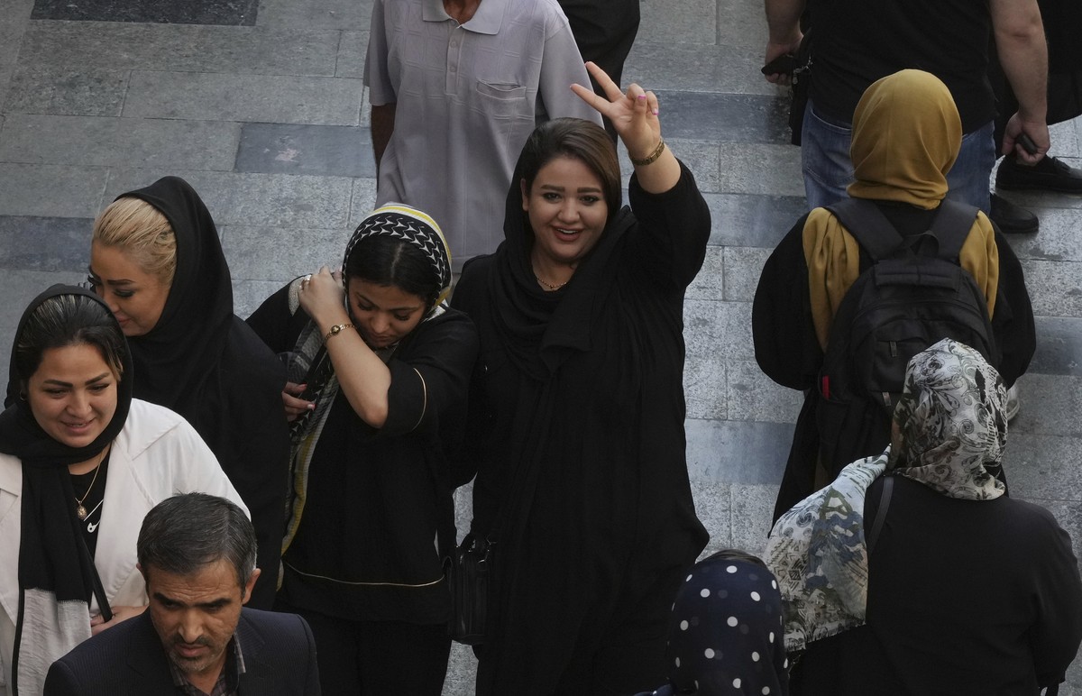A woman flashes a victory sign as she walks around in the old main bazaar of Tehran, Iran, Saturday, Oct. 1, 2022. Thousands of Iranians have taken to the streets over the last two weeks to protest th ...