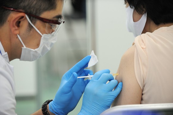 epa09256616 A medical worker administers a dose of vaccine at a mass vaccination site in Tokyo, Japan, 09 June 2021, as the Japan Self-Defense Forces (JSDF) starts a large scale inoculation of COVID-1 ...