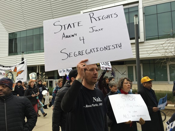 Graduate student Steven Lynn holds up a sign during a protest against U.S. Attorney General Jeff Sessions, who was speaking to the California Peace Officer Association meeting, Wednesday, March 7, 201 ...