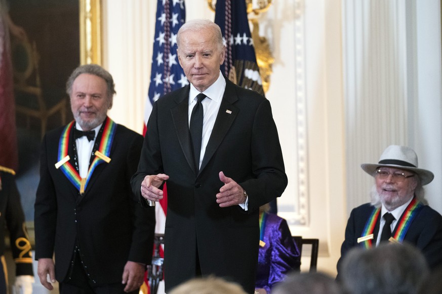 President Joe Biden with 2023 Kennedy Center honorees Billy Crystal, left, and Barry Gibb, right, stand onstage in the East Room during a ceremony honoring the Kennedy Center honorees at the Wh...