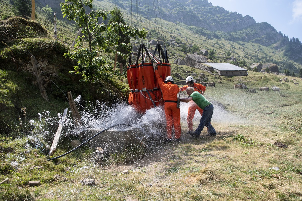 Mitglieder der Schweizer Armee beliefert die Alp Oberbaetruns bei Schaenis mit Wasser fuer die Kuehe, aufgenomme am Freitag, 3. August 2018. (KEYSTONE/Ennio Leanza)