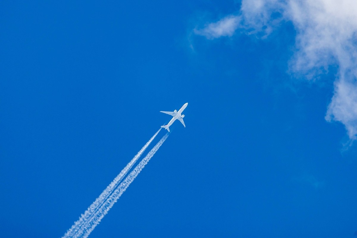 Kodensstreifen am blauen Himmel. Ein zweistrahliges D