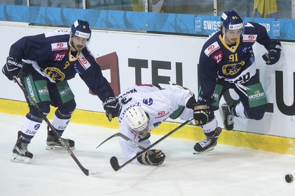 Langenthals Nico Duenner, links, und Jeffrey Fueglister, rechts, im Kampf um den Puck gegen Luganos Julien Vauclaire, Mitte, im Eishockey Achtelfinal Cupspiel zwischen dem SC Langenthal und dem HC Lug ...