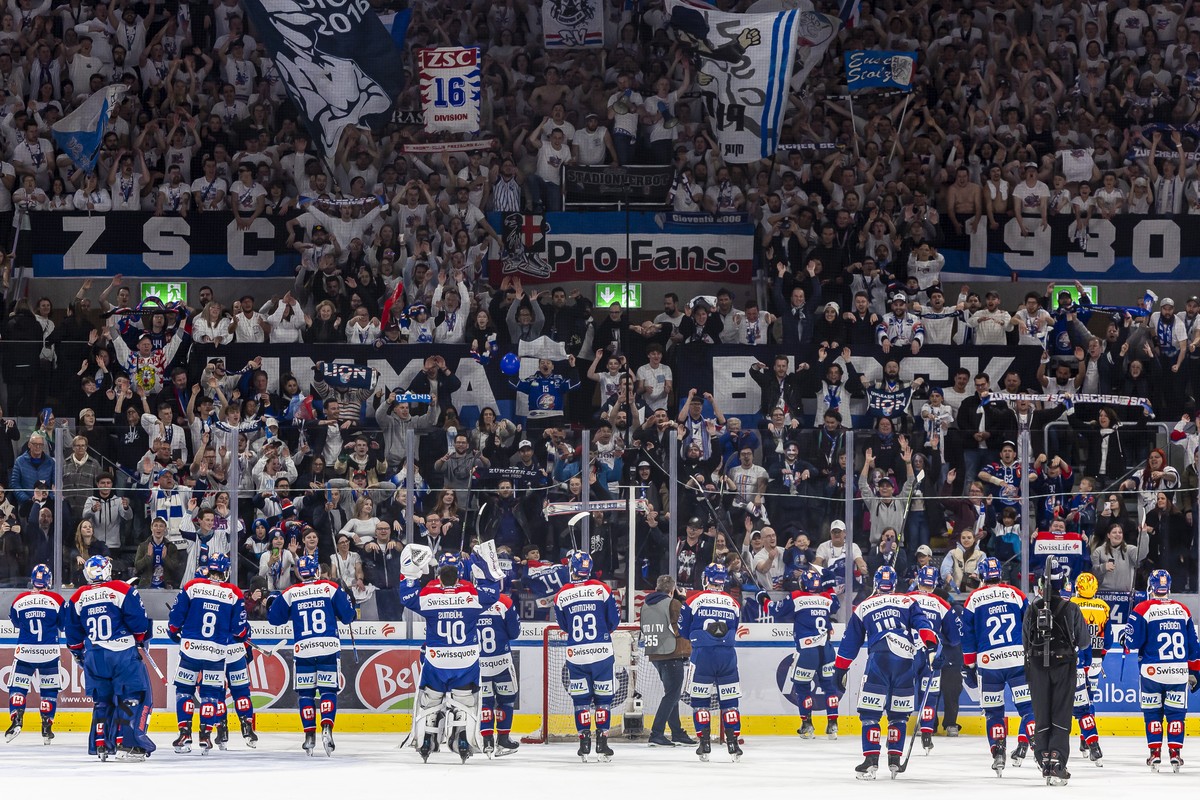 Die Spieler des ZSC jubeln mit ihren Fans nach ihrem Sieg im ersten Playoff Final Eishockeyspiel der National League zwischen den ZSC Lions und Lausanne HC, am Dienstag, 16. April 2024 in der Swiss Li ...