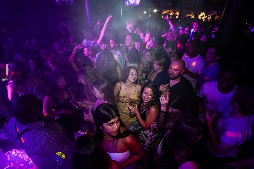 People drink on the dance floor shortly after the reopening, at The Piano Works in Farringdon, in London, Monday, July 19, 2021. Thousands of young people plan to dance the night away at &#039;Freedom ...