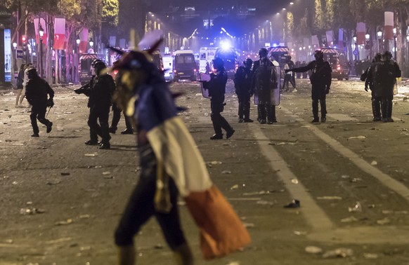 epa06892166 French riot police disperse people on Champs-Elysees avenue after French supporters celebrated the victory of France at the FIFA World Cup 2018 final match against Croatia in Paris, France ...