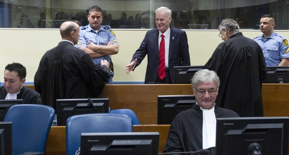 epa06343539 Bosnian Serb military chief Ratko Mladic (C) greets lawyers as he enters the Yugoslav War Crimes Tribunal for the verdict hearing in his genocide trial, in The Hague, Netherlands, 22 Novem ...