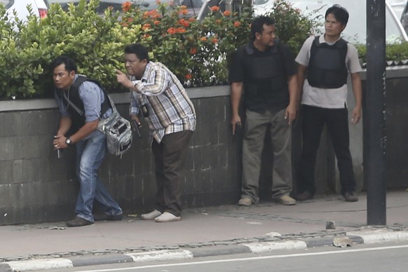 Police officers take their positions as they search buildings near the site of an explosion in Jakarta, Indonesia Thursday, Jan. 14, 2016. Attackers set off explosions at a Starbucks cafe in a bustlin ...