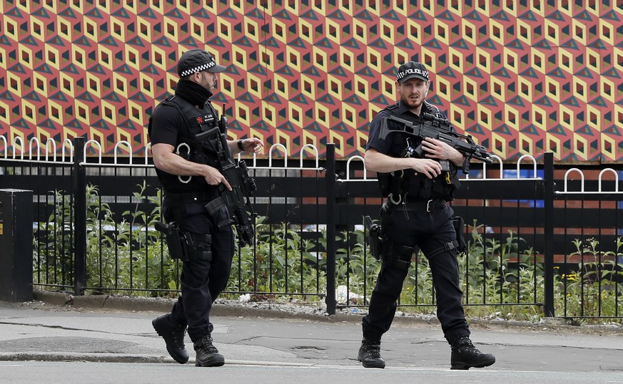 Armed police keep guard near Victoria Station in Manchester, England, Wednesday, May 24, 2017. Britons will find armed troops at vital locations Wednesday after the official threat level was raised to ...