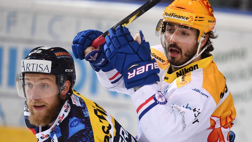 Ambri&#039;s player Jesse Zgraggen, left, fights for the puck with Kloten&#039;s Topscorer Denis Hollenstein, right, during the preliminary round game of National League Swiss Championship 2017/18 bet ...