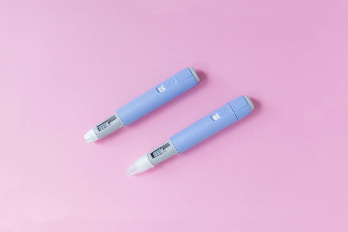medizinisches Medikament Ozempic Injektion liegt auf einem rosa Hintergrund, Draufsicht. Medizin und Gewichtsabnahme, Konzept. Injektoren Dosierstifte für die subkutane Injektion von antidiabetischen  ...