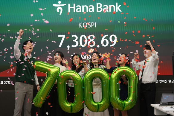 Employees of Hana Bank celebrate in a photo opportunity to mark the Korea Composite Stock Price Index (KOSPI) of over 7,000 points at a dealing room of Hana Bank in Seoul, South Korea, Wednesday, May  ...