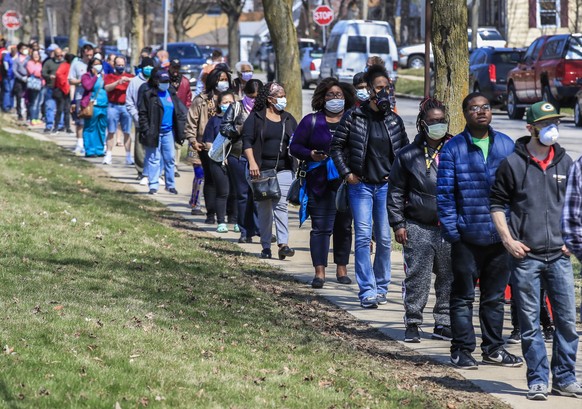 epaselect epa08348941 Voters wait in line to cast their ballots in the Wisconsin presidential primary election at Marshall High School in Milwaukee, Wisconsin, USA, 07 April 2020. After an attempt by  ...