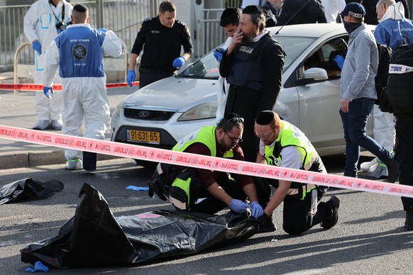 epa11002980 Medical staff remove work in the area of a shooting attack at the entrance of Jerusalem, 30 November 2023. Following an attack by two Palestinian shooters, who also died on the scene, at t ...