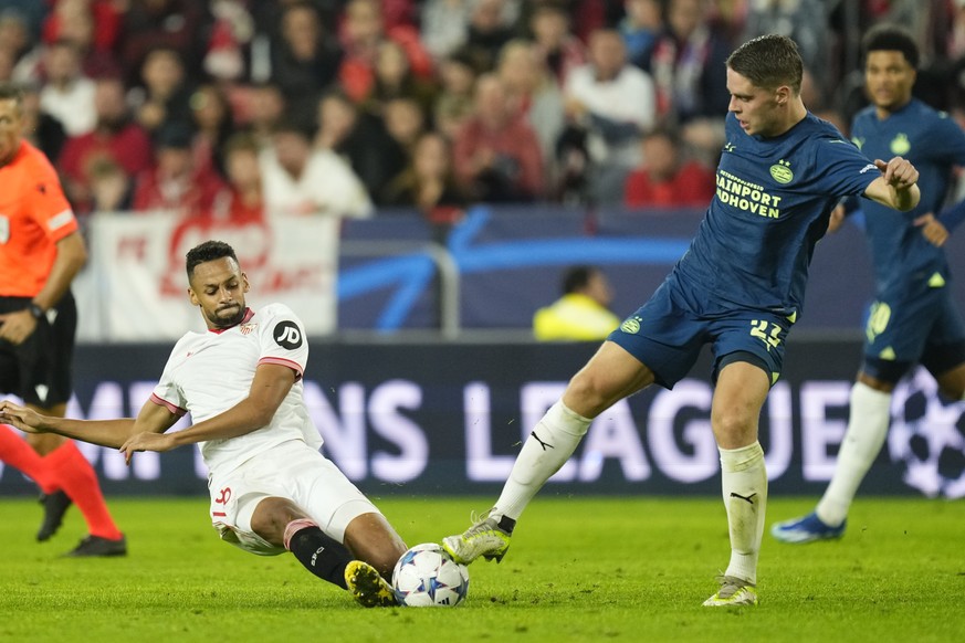 Sevilla&#039;s Djibril Sow challenges for the ball with PSV&#039;s Joey Veerman during the Champions League Group B soccer match between Sevilla and PSV at the Ramon Sanchez-Pizjuan stadium in Seville ...