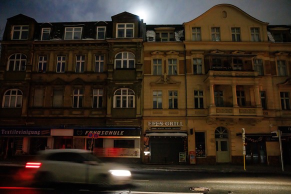 epa12630594 A car passes by dark buildings during a power outage in southwest Berlin, Germany, 06 January 2026. According to state-owned operator Stromnetz Berlin, a large-scale power outage in southw ...