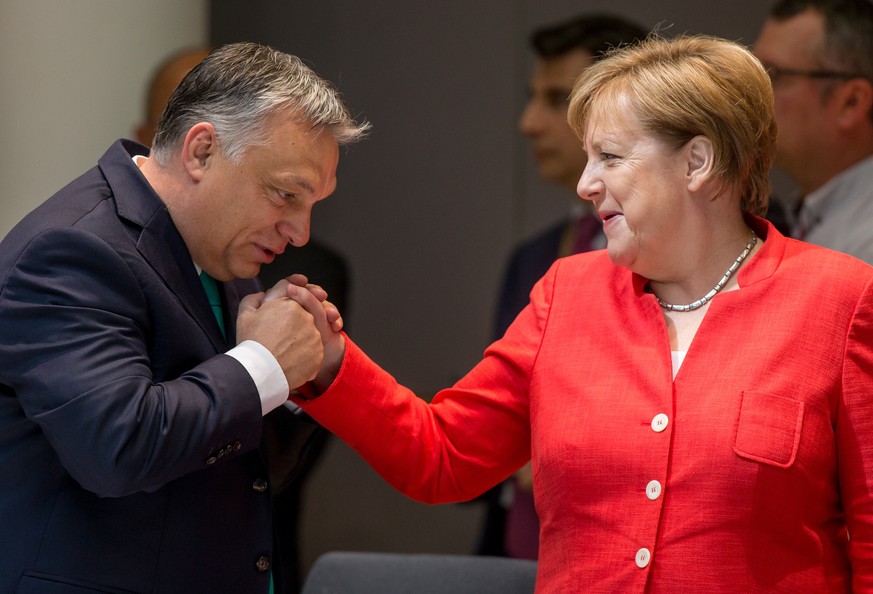 epa06849405 German Chancellor Angela Merkel (R) and Hungarian Prime Minister Viktor Orban (L) at the start of the second day of an European Council summit in Brussels, Belgium, 29 June 2018. EU countr ...