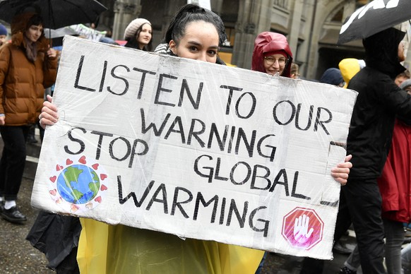 epa07439983 A student holds a placard &#039;Listen to Our Warning, Stop Global Warming&#039; as thousands of students demonstrate during a &#039;Climate strike&#039; protest in Zurich, Switzerland, 15 ...