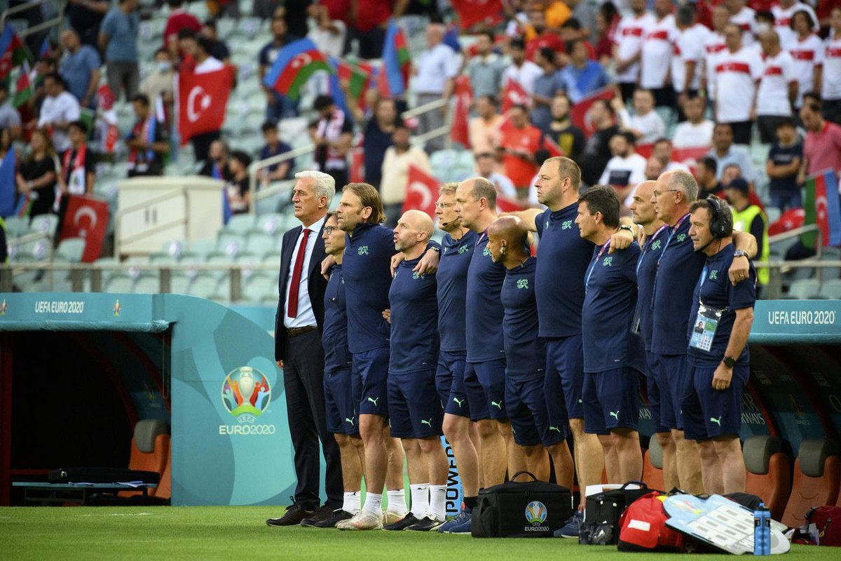 Switzerland's head coach Vladimir Petkovic, left, and technical staffs sing the national anthem during the Euro 2020 soccer tournament group A match between Switzerland and Turkey at the Olympic  ...