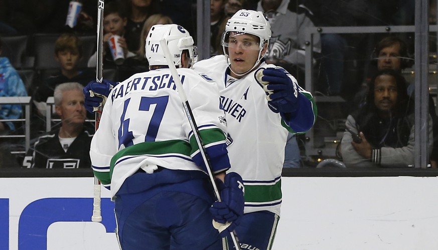 Vancouver Canucks center Bo Horvat, right, congratulates left wing Sven Baertschi, left, of Switzerland, for scoring against the Los Angeles Kings during the first period of an NHL hockey game in Los ...
