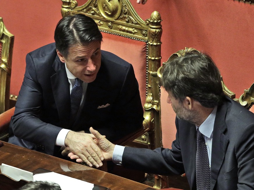 Italian Premier Giuseppe Conte shakes hands with Culture Minister Dario Franceschini, right, at the Senate ahead of a second confidence vote coalition government, in Rome, Tuesday, Sept. 10, 2019. Con ...