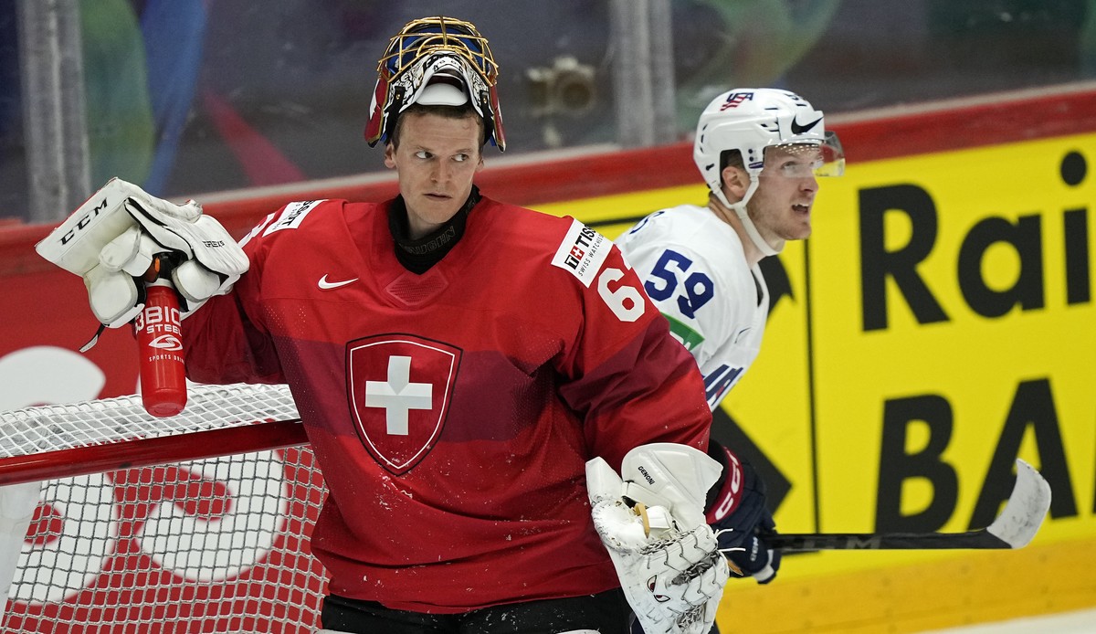 Ben Meyers of the United States, right, passes Switzerland's keeper Leonardo Genoni after he scored the third goal during the Hockey World Championship quarterfinal match between Switzerland and  ...