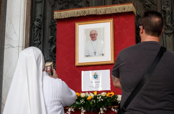 epa12044842 People stand near an image of late Pope Francis at the Basilica of Santa Maria Maggiore in Rome, Italy, 21 April 2025. Pope Francis died on 21 April 2025 at the age of 88, according to the ...