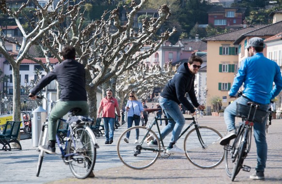 Leute geniessen das schone Wetter an der Uferpromenade von Ascona, am Samstag, 4. April 2020. Bundesrat und Tessiner Regierung hatten schon fuer das vergangene Wochenende explizit dazu aufgerufen, nic ...