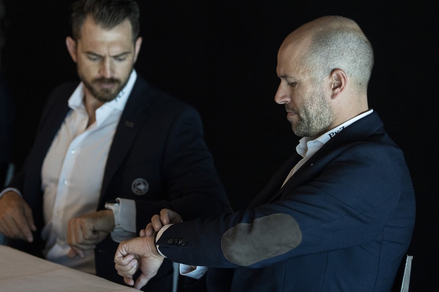 Raeto Raffainer, Chief Sport Officer, links, und Andrew Ebbett, General Manager, konsultieren ihre Uhren, an der Vorsaison Medienkonferenz des SC Bern, am Montag, 30. August 2021, in Bern. (KEYSTONE/P ...