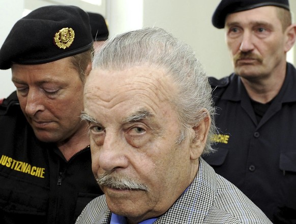 FILE - Josef Fritzl, center, is escorted to the fourth day of his trial in the provincial courthouse in St. Poelten, Austria, Thursday, March 19, 2009. Austrian prosecutors have appealed a court decis ...