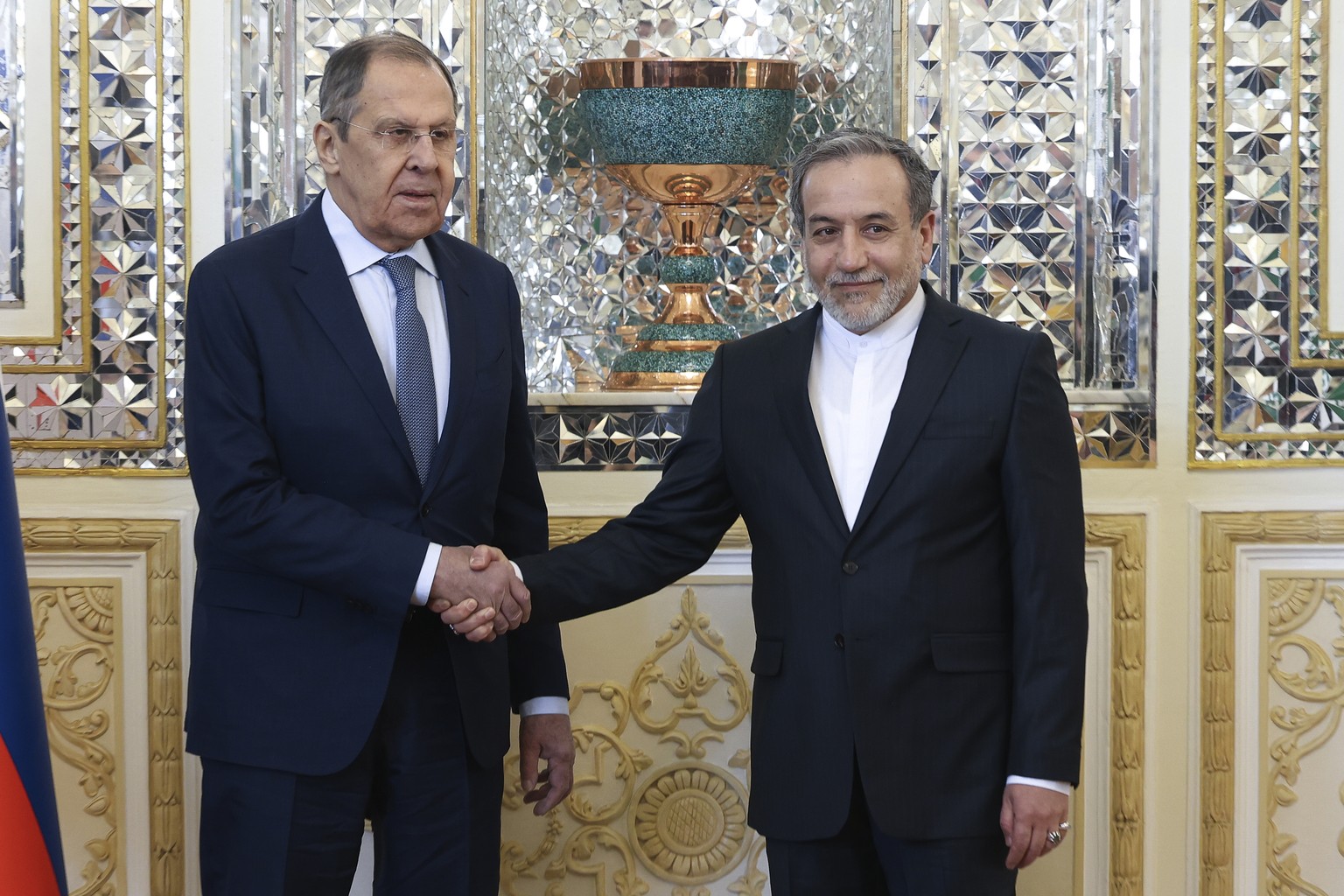 In this photo released by Russian Foreign Ministry Press Service, Russian Foreign Minister Sergey Lavrov, left, and Iranian Foreign Minister Abbas Araghchi shake hands during their meeting in Tehran,  ...