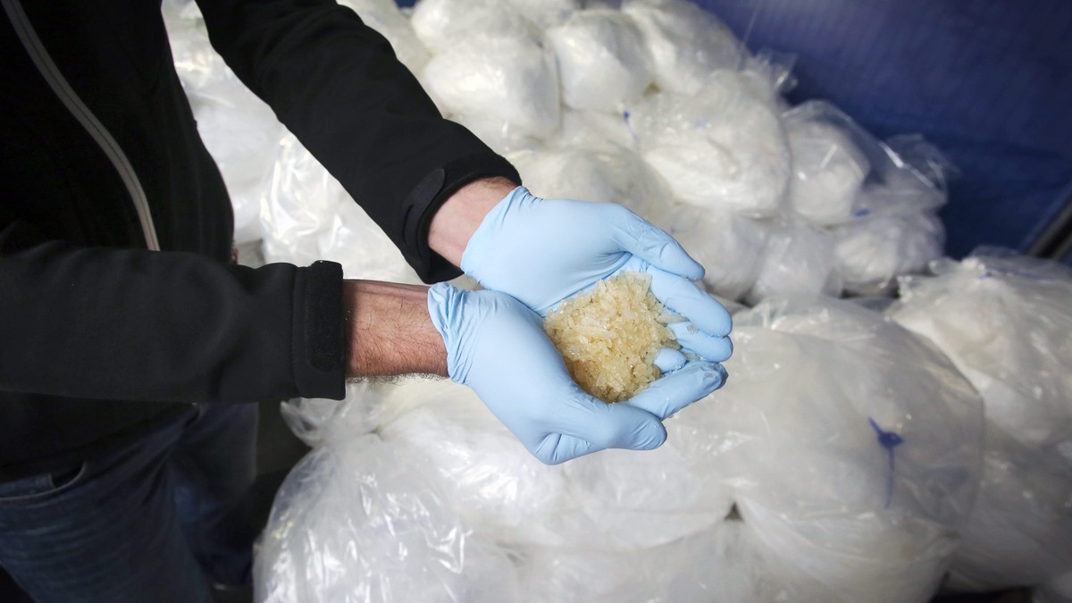 epa04487940 An investigator of the Federal Criminal Police Office (BKA) holds some of 2.9 tons of seized Crystal Meth on display for media in Wiesbaden, Germany, 13 November 2014. Investigators from s ...