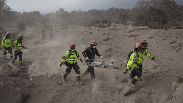 Rescue workers run for cover as the Volcan de Fuego, or &quot;Volcano of Fire,&quot; blows more clouds of ash in the El Rodeo hamlet of Escuintla, Guatemala, Tuesday, June 5, 2018. The fiery volcanic  ...