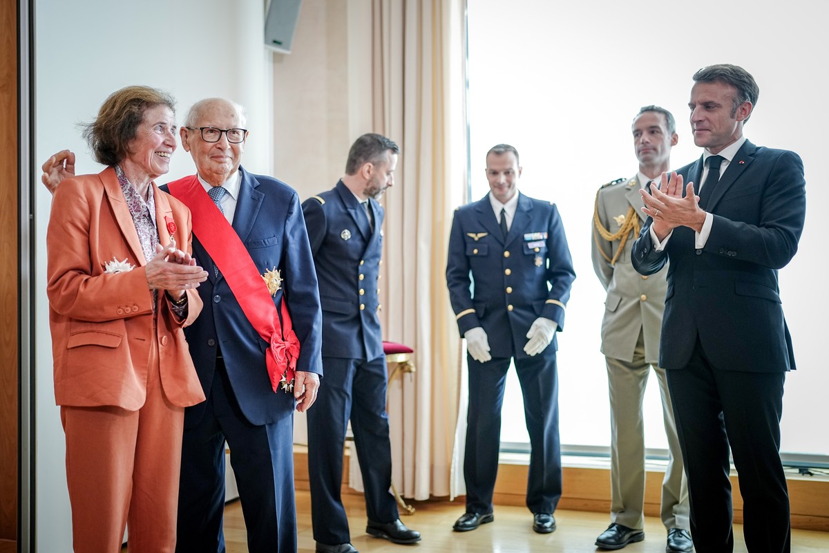 epa11373159 French President Emmanuel Macron (C) applauds after he honored Beate Klarsfeld (L) and Serge Klarsfeld (2-L) with the highest French Order of Merit at the French Embassy in Berlin, Germany ...