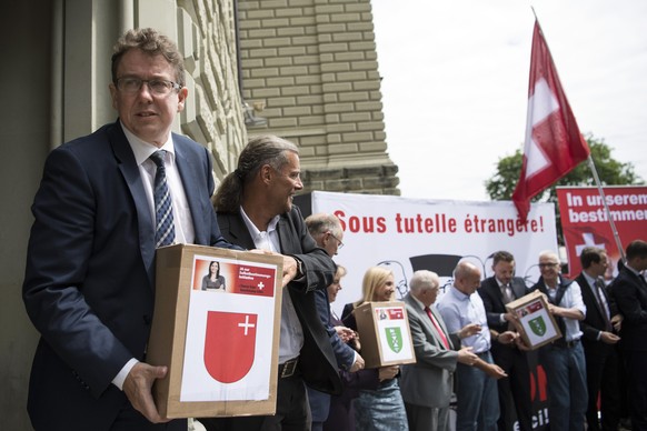 Albert Roesti, Parteipraesident und Nationalrat, links, und Oskar Freysinger, Staatsrat sowie weitere Vertreter der SVP, bei der Einreichung der Selbstbestimmungsinitiative, am Freitag, 12. August 201 ...