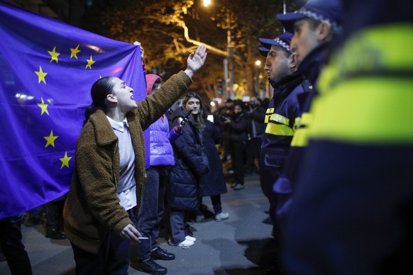 epaselect epa11745744 A Georgian opposition supporter gestures next to an EU flag during a protest in front of the office of the Georgian Dream ruling party in Tbilisi, Georgia, 28 November 2024. Geor ...