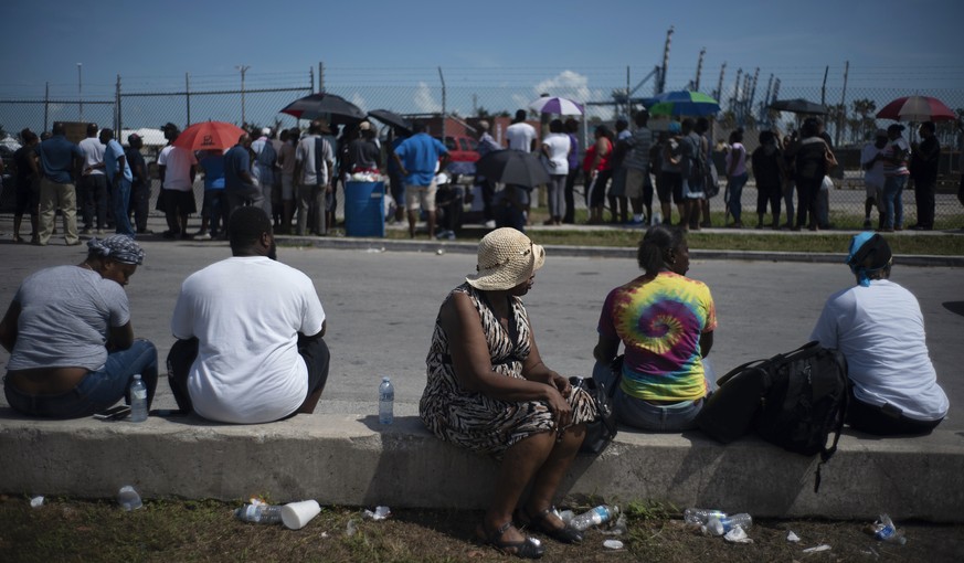 People gather at the port for aid sent by family members and friends in the aftermath of Hurricane Dorian in Freeport, Bahamas, Tuesday, Sept. 10, 2019. Thousands of hurricane survivors are facing the ...