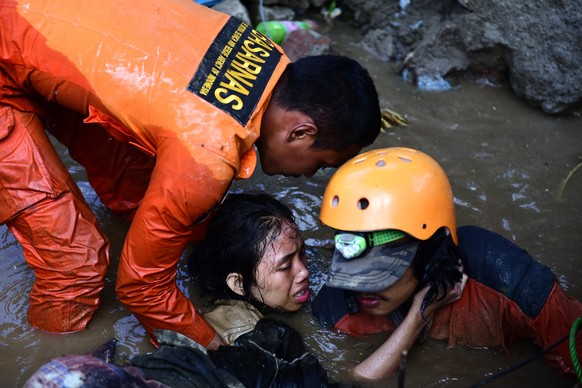 epaselect epa07058657 Indonesian rescuers try to free a 15-year-old earthquake survivor, Nurul Istikhomah from the flooded ruins of a collapsed house in Palu, Central Sulawesi, Indonesia, 30 September ...
