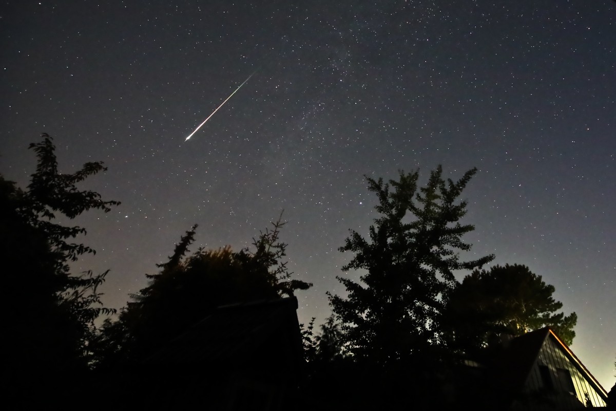 13.08.2023, Schleswig-Holstein, Neumünster: Ein Perseidenmeteor zieht über den Himmel gegen 04:00 Uhr MESZ in Neumünster (Stadtteil Tungendorf). Ab 23 Uhr hatte sich der Himmel über weiten Teilen Schl ...